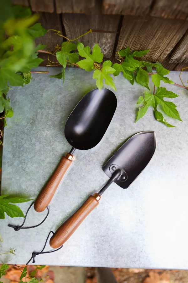Matching set of black steel and walnut wood garden trowel and scoop, stamped with the Barebones wordmark.