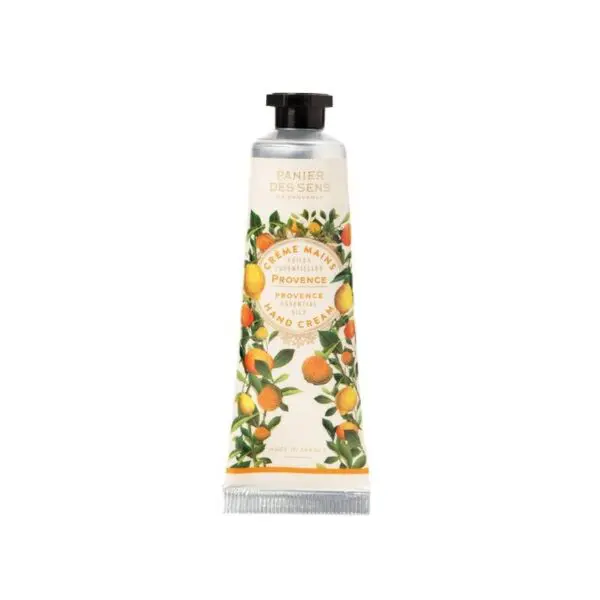 A tube of hand cream is displayed, featuring a design inspired by Provence. The tube is predominantly white with illustrations of citrus fruits, including oranges and lemons, surrounded by green leaves. The label reads "Crème Mains" and "Provence Essential Hand Cream," indicating its purpose and origin. The cap is black, and the overall aesthetic is fresh and vibrant, reflecting a natural and botanical theme.