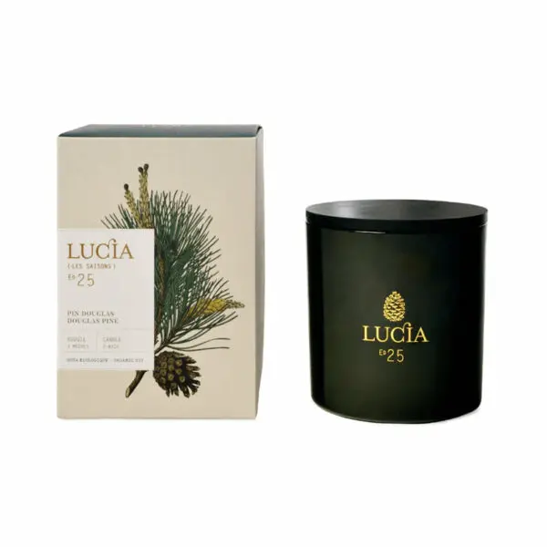 A black candle jar with a gold logo reading "LUCÍA ed 25" sits next to a decorative box. The box features an illustration of a Douglas pine branch with pine cones and includes text indicating it is a candle. The packaging is designed with a natural aesthetic, emphasizing the pine scent.