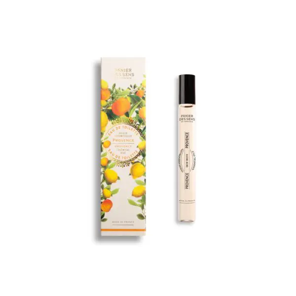 A slender glass bottle of eau de toilette is displayed alongside its decorative packaging. The bottle features a black cap and a label that reads "PROVENCE" in a circular design. The packaging is adorned with vibrant illustrations of lemons and leaves, emphasizing a fresh and citrusy theme. The text on the box includes "Eau de Toilette" and "Panier des Sens," indicating the brand and product type. The overall aesthetic is bright and inviting, reflecting a connection to the Provence region of France.