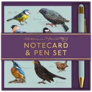 A notecard and pen set featuring beautifully illustrated birds on the notecards. The designs include a Blue Tit, Starling, Great Tit, Kingfisher, Blackbird, and Wren, all set against a soft blue background. The set is packaged with a rich purple band that reads "Patricia MacCarthy NOTECARD & PEN SET" in gold lettering. A light blue pen with a gold tip is included, complementing the overall aesthetic.