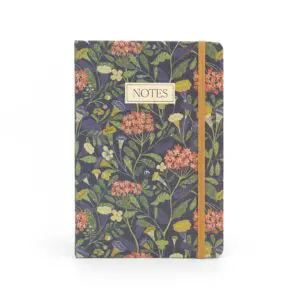 A notebook with a floral design featuring a variety of colorful flowers and green leaves against a dark background. The cover includes a rectangular label that reads "NOTES" in a simple font. An elastic band in a warm tone secures the notebook. The overall aesthetic is vibrant and nature-inspired.