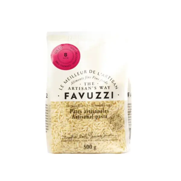 A clear plastic bag of Favuzzi artisanal pasta, specifically orzo, is displayed. The bag contains 500 grams of the pasta, which is small, rice-shaped, and light beige in color. The front features a pink circular label indicating a cooking time of 8 minutes. The packaging includes both English and French text, highlighting the product's artisanal quality and slow-drying process.