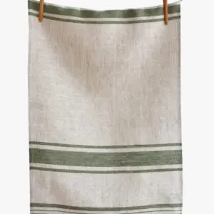 A textured linen towel is hanging from a wooden peg on a string. The towel features a light beige base with two horizontal green stripes at the top and a series of thin green lines towards the bottom, creating a simple yet elegant design. The fabric appears soft and natural, emphasizing a rustic aesthetic.