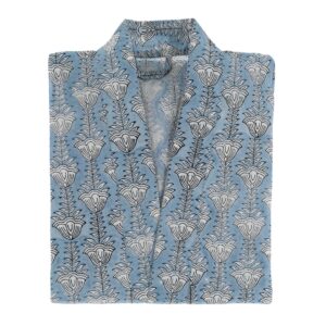 A folded garment featuring a light blue fabric adorned with a repeating floral pattern in black. The design consists of stylized flowers and leaves arranged vertically. The collar is open, showcasing the interior of the garment. The overall look is elegant and suitable for casual or semi-formal wear.