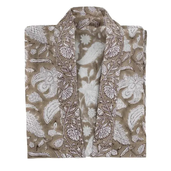 A folded garment featuring a floral and leaf pattern in white on a light brown background. The design includes intricate details of flowers and leaves, creating a textured appearance. The garment has an open front, suggesting it may be a kimono or similar style. The fabric appears lightweight and suitable for casual wear.