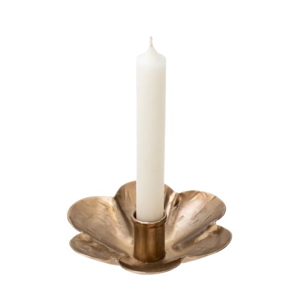 A decorative candle holder shaped like a flower, made of a metallic material with a brushed gold finish. It features a central cylindrical holder for a white taper candle, which is upright in the middle of the flower's petal-like base. The petals are slightly curved and have a textured surface, enhancing the overall aesthetic.