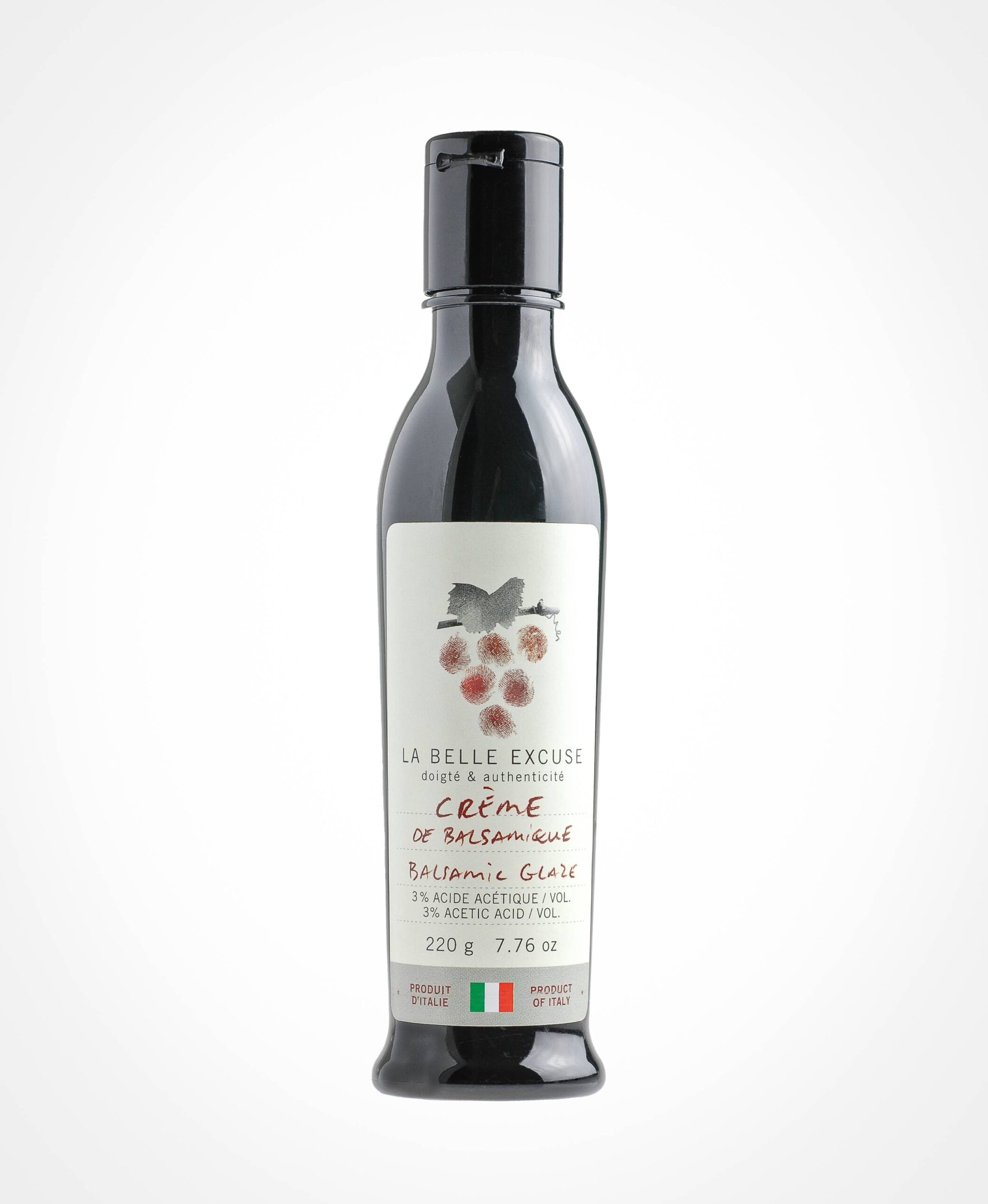 Bottle of La Belle Excuse balsamic glaze, labeled "Crème de Balsamique" with 3% acetic acid, weighing 220g (7.76 oz), product of Italy. The label features a cluster of grape fingerprints and text in French and English.